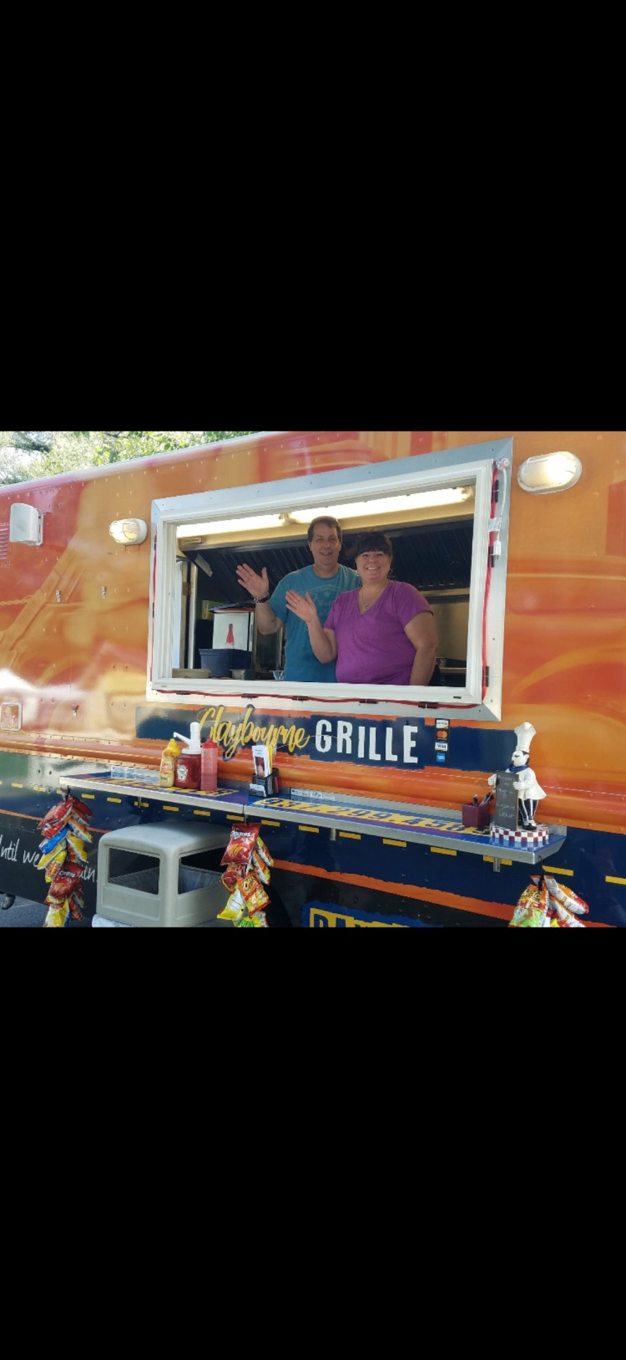 Claybourne Grille owners waving from the food truck window